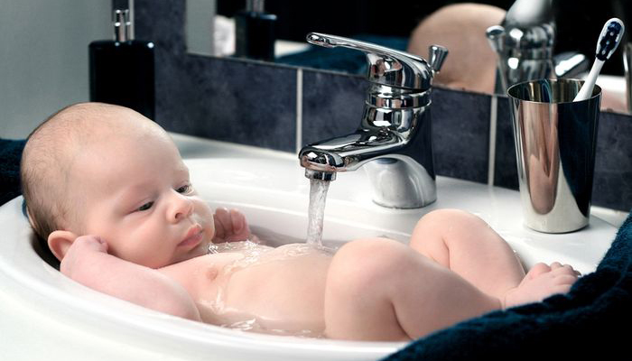 Купать в кипяченой воде. Ребенок в раковине. Подмывание ребенка в раковине. Раковина для подмывания младенцев. Кран для подмывания младенцев.